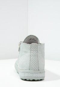 Světle šedá kotníková bota vyrobená z texturovaného syntetického materiálu s hadím vzorem. Obsahuje boční zip a plochou gumovou podrážku.