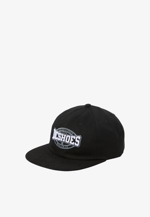 Gorra negra de algodón, con visera plana. Logotipo bordado "DC Shoes" en blanco, con un diseño de insignia circular en la parte frontal.