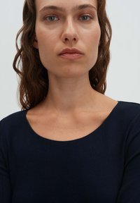 Dunkelblaues, geripptes Langarmoberteil mit weitem Rundhalsausschnitt. Glatte Textur und enganliegendes Design. Geeignet für die Freizeit.