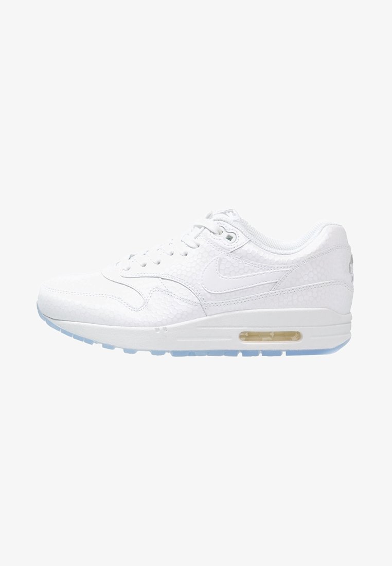Nike Air Max blanches avec un dessus texturé, amorti visible dans une semelle transparente, lacets traditionnels et une finition en cuir lisse.