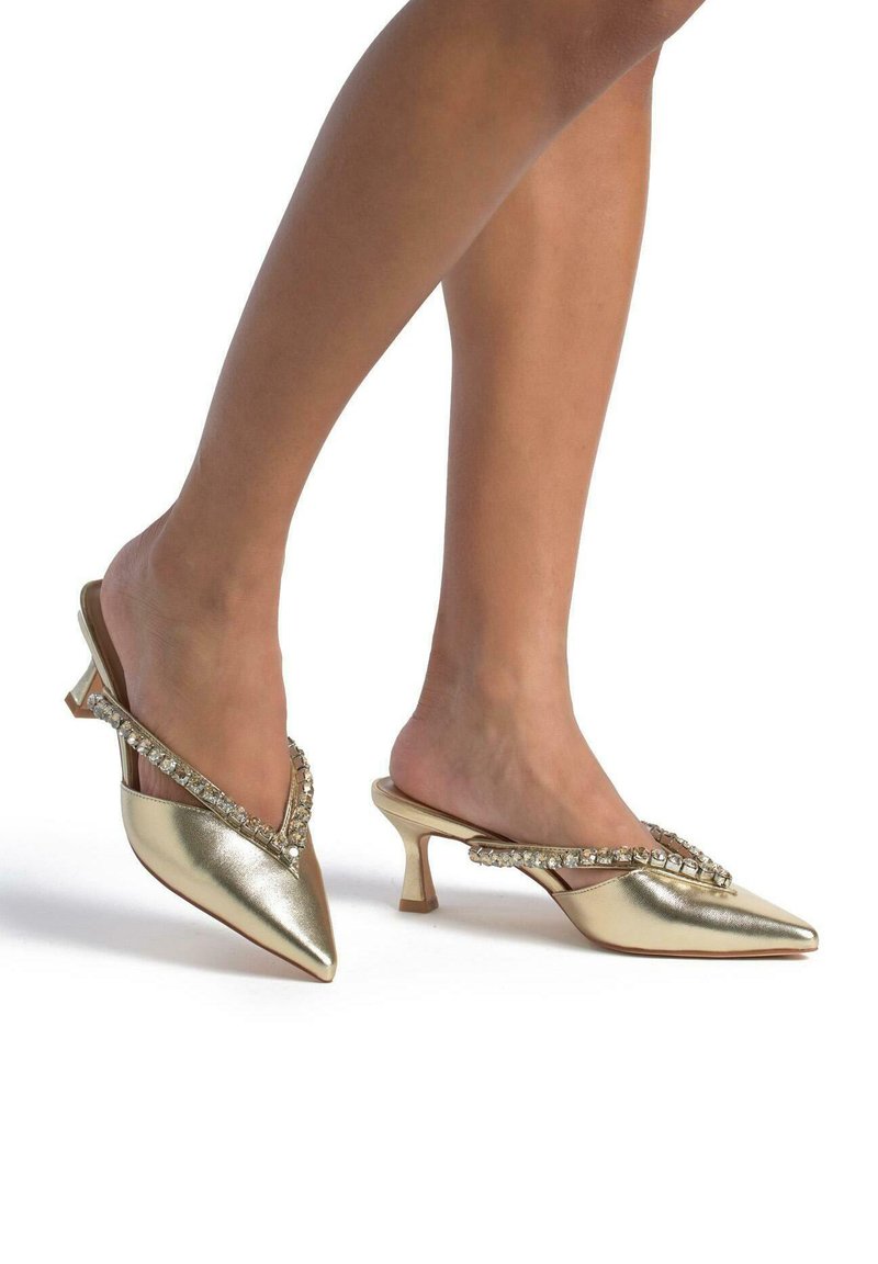 Escarpins slingback métalliques dorés avec un bout pointu et des embellissements en cristal le long de la sangle ; dotés d'un petit talon épais.