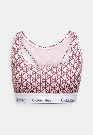 Urheiluliivit, joissa on punainen ja kerma beige geometrinen kuvio, valkoinen nauha, jossa on Calvin Kleinin logo, ja ristiselkäinen muotoilu.