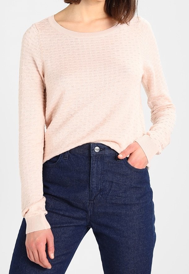 Suéter texturizado de color rosa claro con cuello redondo y mangas largas, combinado con jeans de tiro alto de color azul oscuro con cierre de botón.