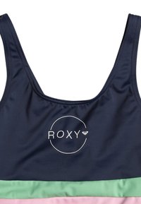 Granatowy top na ramiączkach z logo ROXY w białym kole, zestawiony z miętowymi i jasnoróżowymi taśmami materiałowymi na dole.