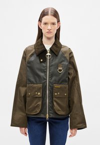 Brown and black jacket with a corduroy collar, zip closure, and two front pockets. Features a gold accent and a loop detail near the neck.