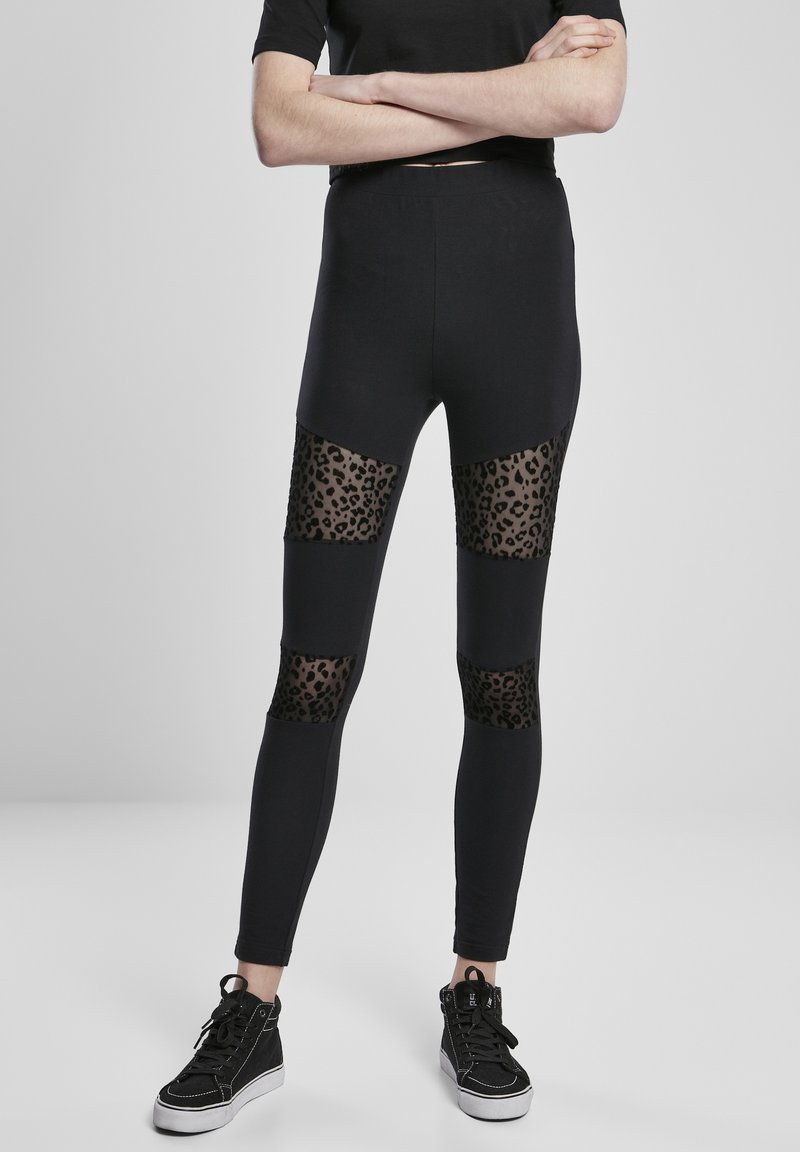 Čierne legíny s vložkami z priehľadnej sieťoviny a akcentmi s leopardím vzorom na kolenách. Hladká látka s priliehavým strihom a elastickým pásom.