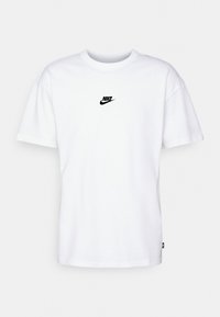 Bílá bavlněná tričko s kulatým výstřihem, krátkými rukávy a malým černým logem Nike na hrudi. Klasický fit s rovnou spodní částí.