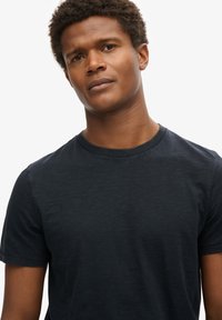 T-shirt navy blu con collo a giro, realizzato in tessuto morbido, con maniche corte e vestibilità classica. Design minimalista, senza motivi o accenti visibili.