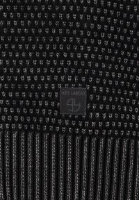 Maglione nero a maglia con motivo testurizzato, orlo a costine e una patch con logo che legge "KEY LARGO" nella parte inferiore sinistra.