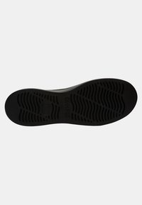 Black rubber shoe sole with textured tread design, featuring grooves and a central logo. The shape is rounded with a slight curve at the heel.