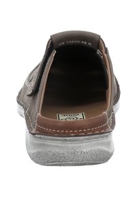 Braune Leder-Schlupfschuhe mit einer strukturierten Sohle, kontrastierenden Nähten und einem breiten Schnitt. Das Innere ist gepolstert und mit einem braunen Stofffutter versehen.
