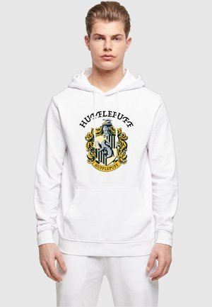 Hvid hættejakke med snore, der har et farverigt Hufflepuff-våbenskjolddesign i midten. Fremstillet af blødt, tekstureret materiale. Foran lomme.