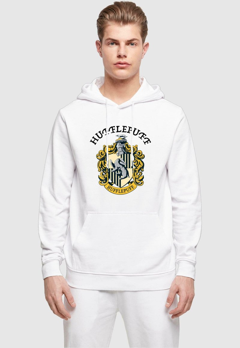 Fehér kapucnis pulóver zsinórokkal, középen egy színes Hufflepuff címerrel. Puha, textúrált anyagból készült. Elülső zsebbel.