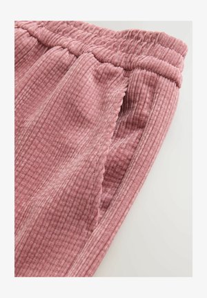 Rózsaszín bordázott anyagú nadrág, elasztikus derékkal és oldalsó zsebekkel, puha tapintással és finom, hullámos szegéllyel.