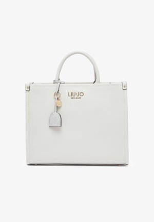 Bolso blanco de cuero sintético con logo dorado, diseño estructurado, doble asa superior y un llavero decorativo. Presenta una textura suave y un estilo minimalista.