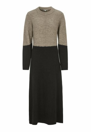 Strickkleid mit beigem Oberteil, schwarzem Unterteil und langen Ärmeln. Das Design zeichnet sich durch eine gerade Silhouette und Kontrastnähten am Saum aus.