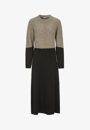 Strickkleid mit beigem Oberteil, schwarzem Unterteil und langen Ärmeln. Das Design zeichnet sich durch eine gerade Silhouette und Kontrastnähten am Saum aus.