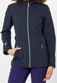 Giacca blu navy di lunghezza media con chiusura a zip, cappuccio e due tasche laterali. Presenta un tessuto testurizzato e una sottile lavorazione delle cuciture.