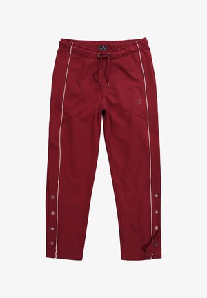 Viininpunaiset verkkarihousut valkoisilla sivuviivoilla, joustava vyötärönauha kiristysnyörillä, nappikiinnitys alareunassa ja hillitty logo reisiosassa.