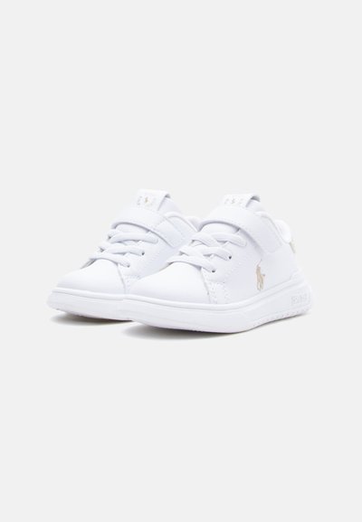 Zapatillas blancas para niños pequeños con cordones y cierres de velcro, que presentan un pequeño logotipo bordado en el lateral y cuellos acolchados.