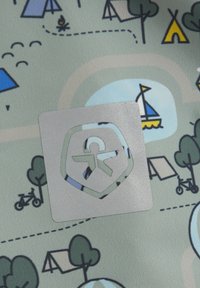 Wzorzysty materiał przedstawia różne ikony obozowe, w tym namioty, drzewa i łódź, z wyraźnie widocznym srebrnym logo.