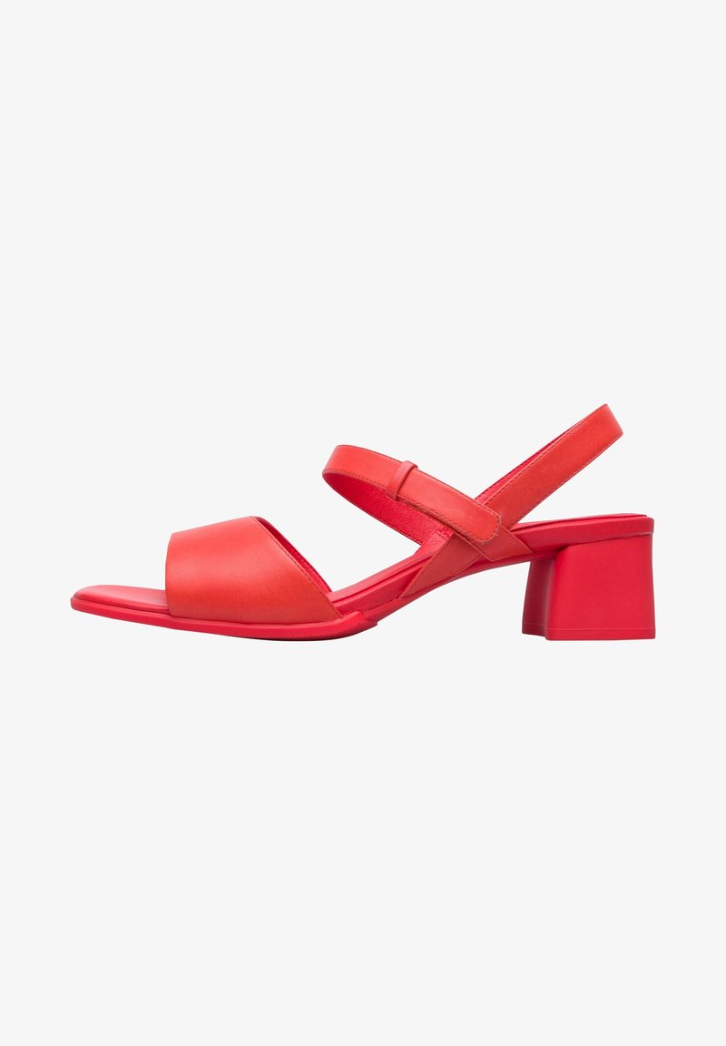 Sandale rouge ouverte à l'avant avec deux brides, dont une autour de la cheville avec une fermeture velcro, et un petit talon bloc.