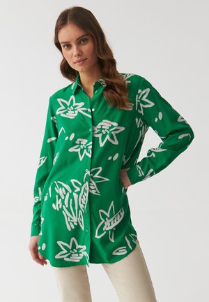 Camicia verde a maniche lunghe con bottoni, caratterizzata da una stampa floreale bianca. Realizzata in tessuto morbido con una vestibilità comoda.