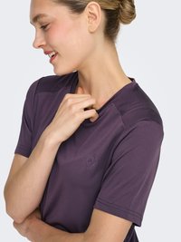 Paarse sport T-shirt met een ronde hals, korte mouwen, gestructureerde accenten op de schouders en een subtiel logo op de voorkant.