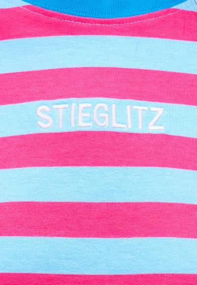 Ύφασμα με οριζόντιες ρίγες σε ροζ και ανοιχτό μπλε χρώμα, με λευκό κεντητό κείμενο "STIEGLITZ" στο κέντρο κάτω από γαλάζιο ριμπ ύφασμα στο γιακά.