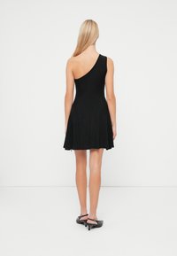 Rochie neagră, cu un singur umăr, cu un corp ajustat și fustă evazată. Textură moale, de lungime până la genunchi, cu un design minimalist și fără modele vizibile.