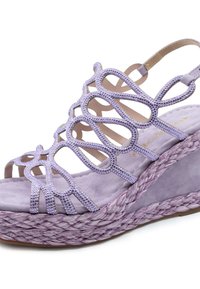 Sandalo a cuneo viola con suola in juta intrecciata. Presenta una tomaia con ritagli e accenti scintillanti, e una soletta in morbida pelle scamosciata.