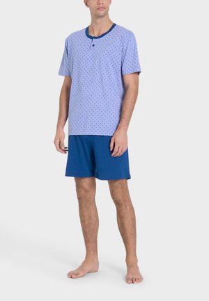 Maglietta da pigiama azzurro chiaro a maniche corte con scollo blu scuro, caratterizzata da un motivo a pois; abbinata a pantaloni short blu navy senza stampa.