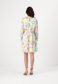 Robe fleurie avec une palette de couleurs pastel comprenant des fleurs jaunes, roses et bleues. Manches longues, taille cintrée et détail dos avec une ouverture en forme de trou de serrure.