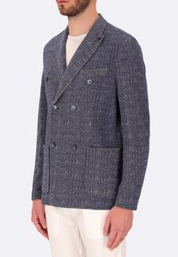 Blazer doppiopetto in tessuto navy testurizzato. Presenta due grandi tasche frontali e bottoni tono su tono, con una vestibilità complessivamente sartoriale.