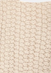 Tessuto in pizzo beige con un motivo floreale, caratterizzato da dettagli intricati e una superficie leggermente testurizzata. Aspetto leggero e delicato.