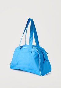 Μπλε σακίδιο με λευκή επένδυση, δύο μακριές λαβές και φερμουάρ στην κορυφή, τοποθετημένο σε απλό ανοιχτό φόντο.