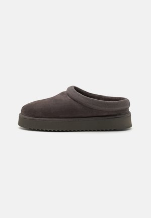 Szürke velúr slip-on klumpák kerek orral, párnázott gallérral és texturált gumitalppal, amelyen cikcakk mintázatú vonalak találhatók a tapadás érdekében.