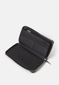 Black leather wallet interior with soft texture, featuring multiple card slots and a zipped compartment, finished with silver zipper hardware.