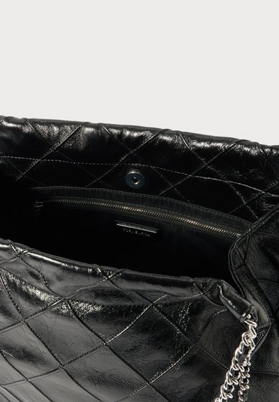 Svart quiltad läderhandväska med silverkedjedetalj, utrustad med öppet toppgrepp och innerficka med dragkedja för säker förvaring.