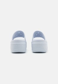 Ciabatte in gomma bianche con design aperto sul retro. Presentano fori di ventilazione sui lati e una suola testurizzata e di supporto con il marchio "crocs".