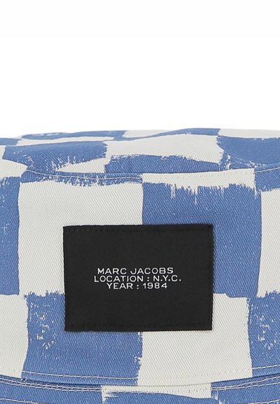 Borsa in tessuto con motivo blu e bianco con un'etichetta rettangolare nera che presenta testo bianco: "MARC JACOBS LOCATION: N.Y.C. YEAR: 1984."