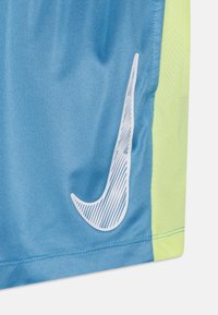 Pantalones cortos deportivos azules con un panel lateral de color amarillo neón, que presentan el logotipo de Nike en blanco en la parte frontal. Confeccionados en un tejido ligero y texturizado.