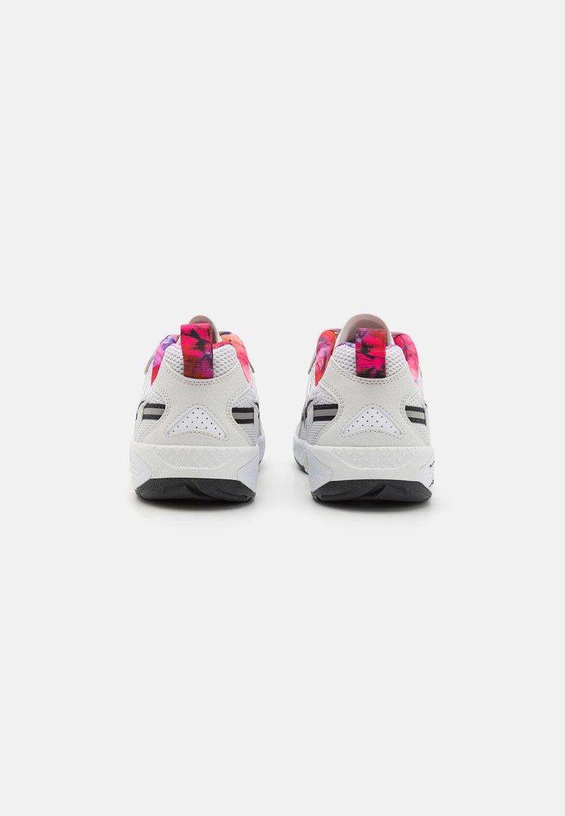 Zapatilla blanca con material texturizado, suela gris y talón de diseño multicolor. Presenta franjas negras dobles y soporte acolchado.