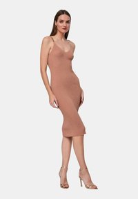 Abito midi in maglia di un rosa tenue con una silhouette aderente, caratterizzato da sottili spalline e dettagli in catena dorata. Tessuto liscio.