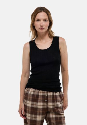 Débardeur noir à côtes avec un col en scoop, associé à un pantalon à carreaux marron et beige avec des boutons. Tissu doux avec une coupe près du corps.