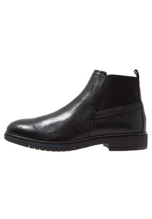 Bottines noires en cuir au fini lisse, présentant des panneaux latéraux élastiques, des accents texturés et un talon empilé bas.