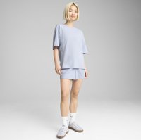 T-shirt azzurro chiaro in cotone e pantaloni corti abbinati con una vestibilità comoda, abbinati a calze bianche e sneakers grigio chiaro con suole marroni.
