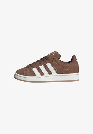 Brune ruskinds sneakers med hvide læderstriber, gummisål, rund tå og snørebåndsfront. Har et logo på tungen og perforerede detaljer.