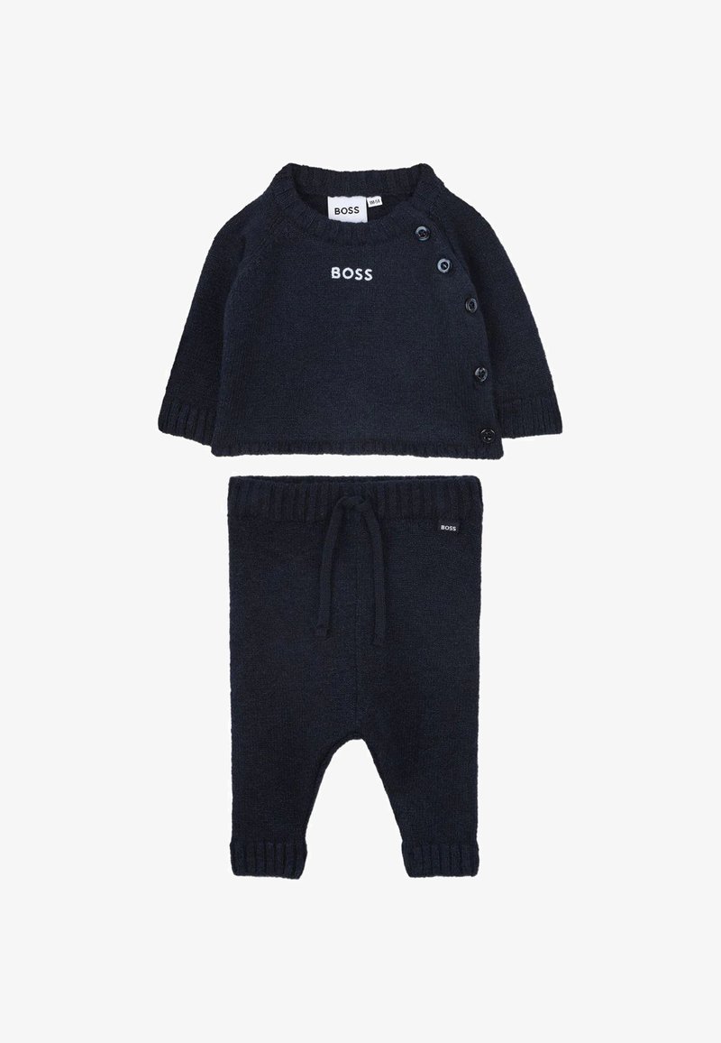 Ensemble pour bébé en tricot bleu marine comprenant un haut à manches longues avec des boutons sur le côté et un pantalon assorti avec taille à cordon, tous deux portant l'inscription "BOSS".