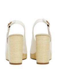 White platform heels with a woven beige texture on the heel. Features a strap with a gold buckle, smooth upper material, and rounded toe.